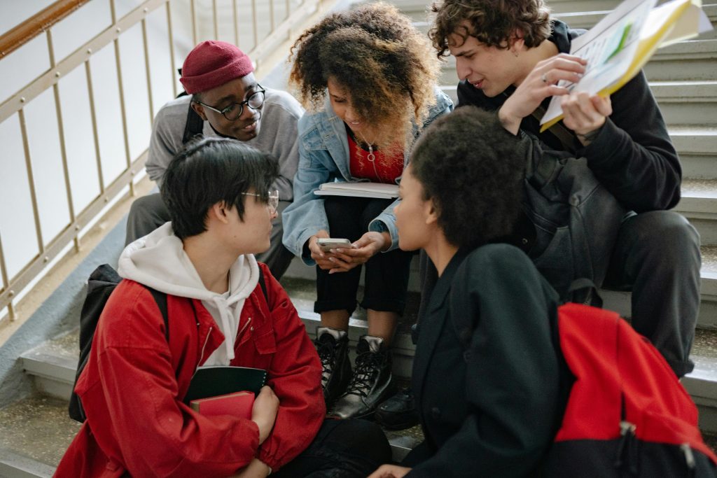 young people gathered around a cell phone