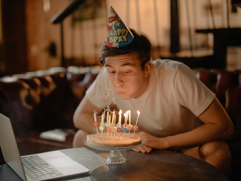 boy blowing out candles on a cake celebrating turning 18