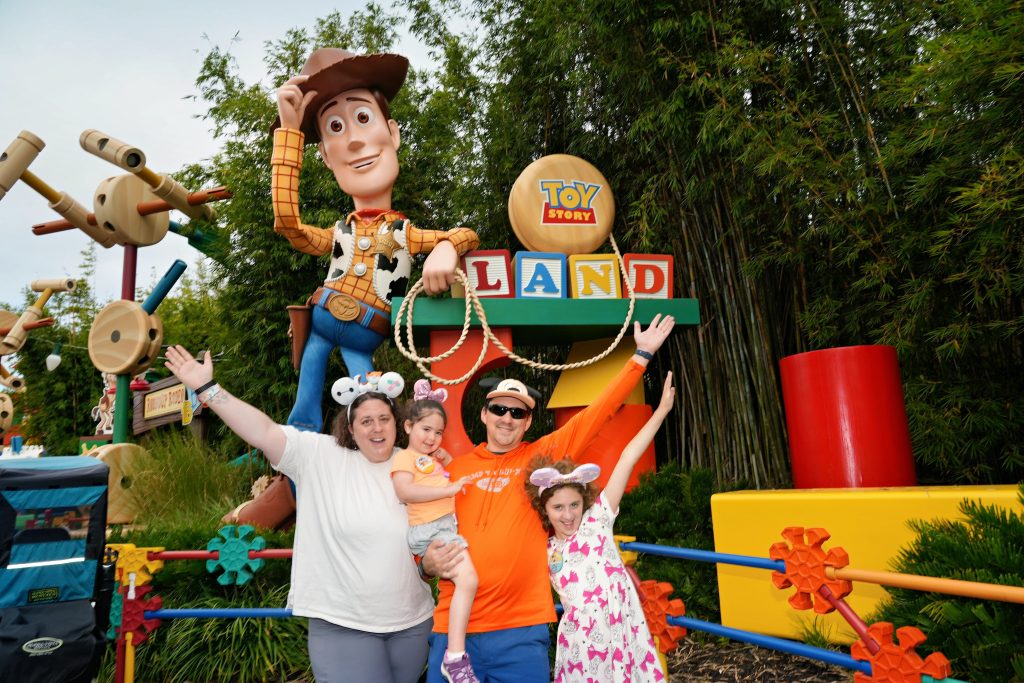 family posing in front of a toy story ride at Disney World