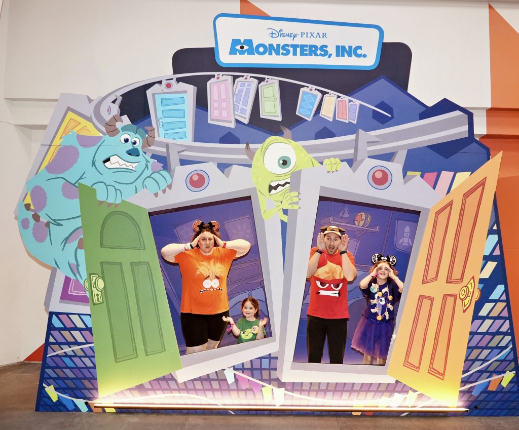 Happy family in a Monsters Inc set at Disney World
