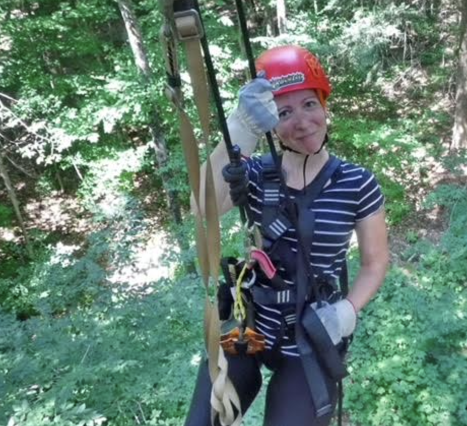woman on a zipline, smiling at the camera